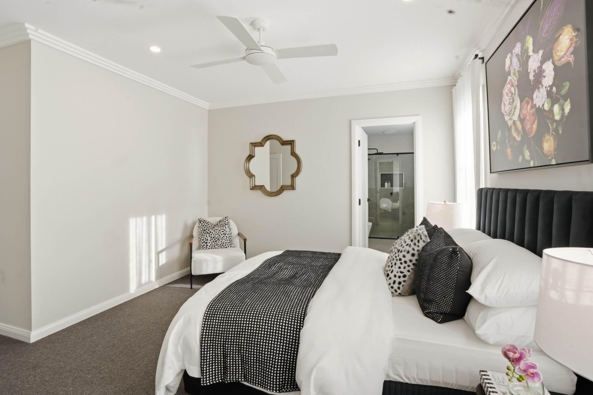 Master bedroom side view with quatrefoil mirror and ensuite door