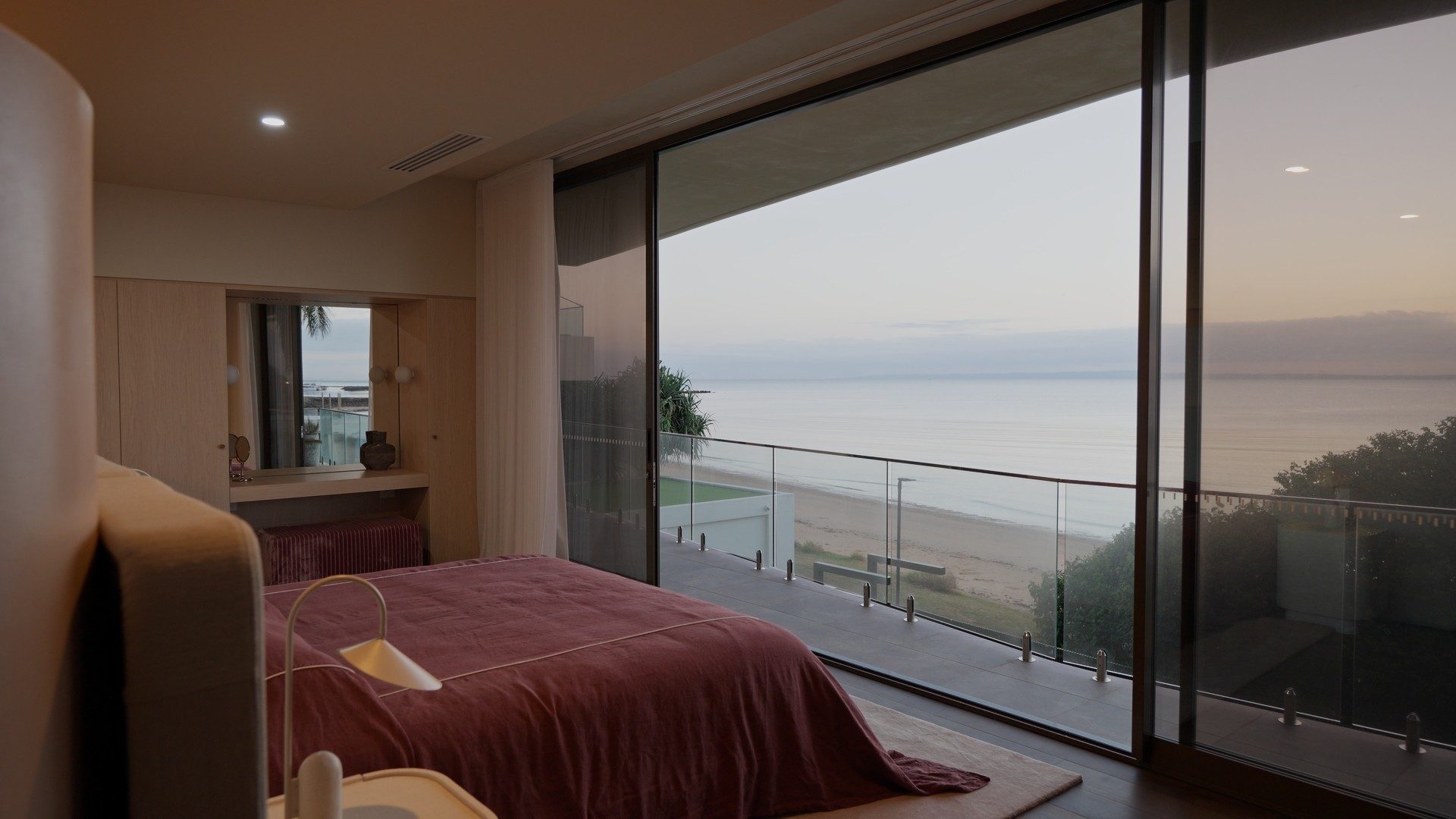 Bedroom at Horizon by Graya opening onto a balcony above the beach and bay