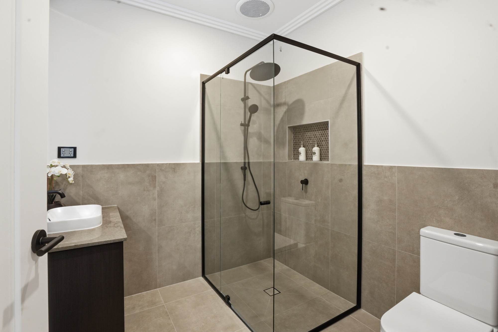 Ensuite with black-framed shower screen, rain head and mosaic niche