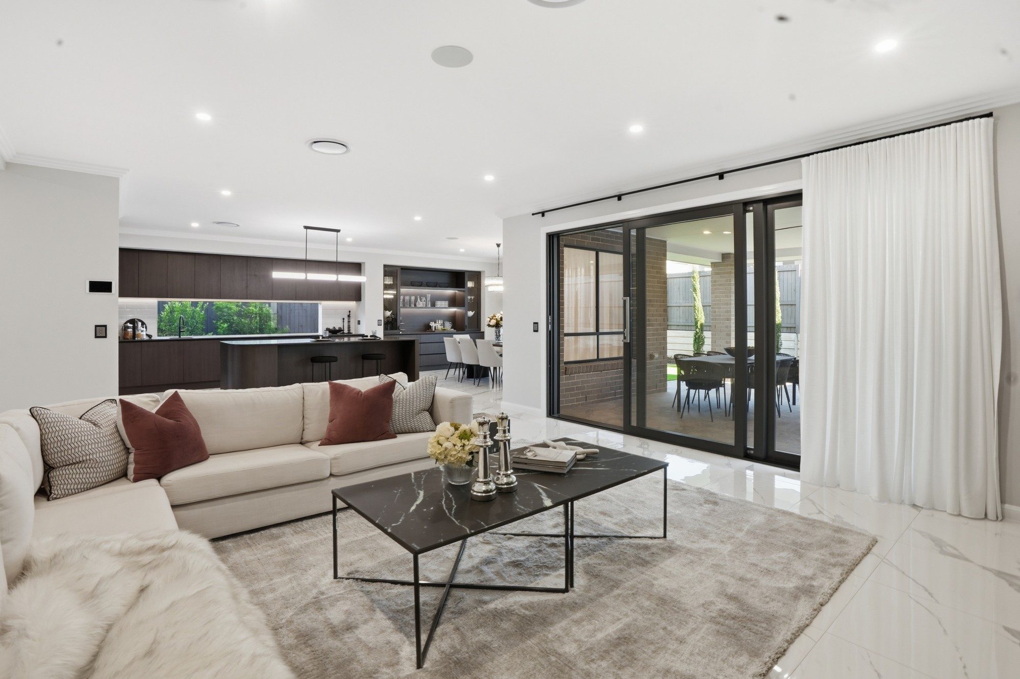 Family room opening through sliding doors to a covered alfresco