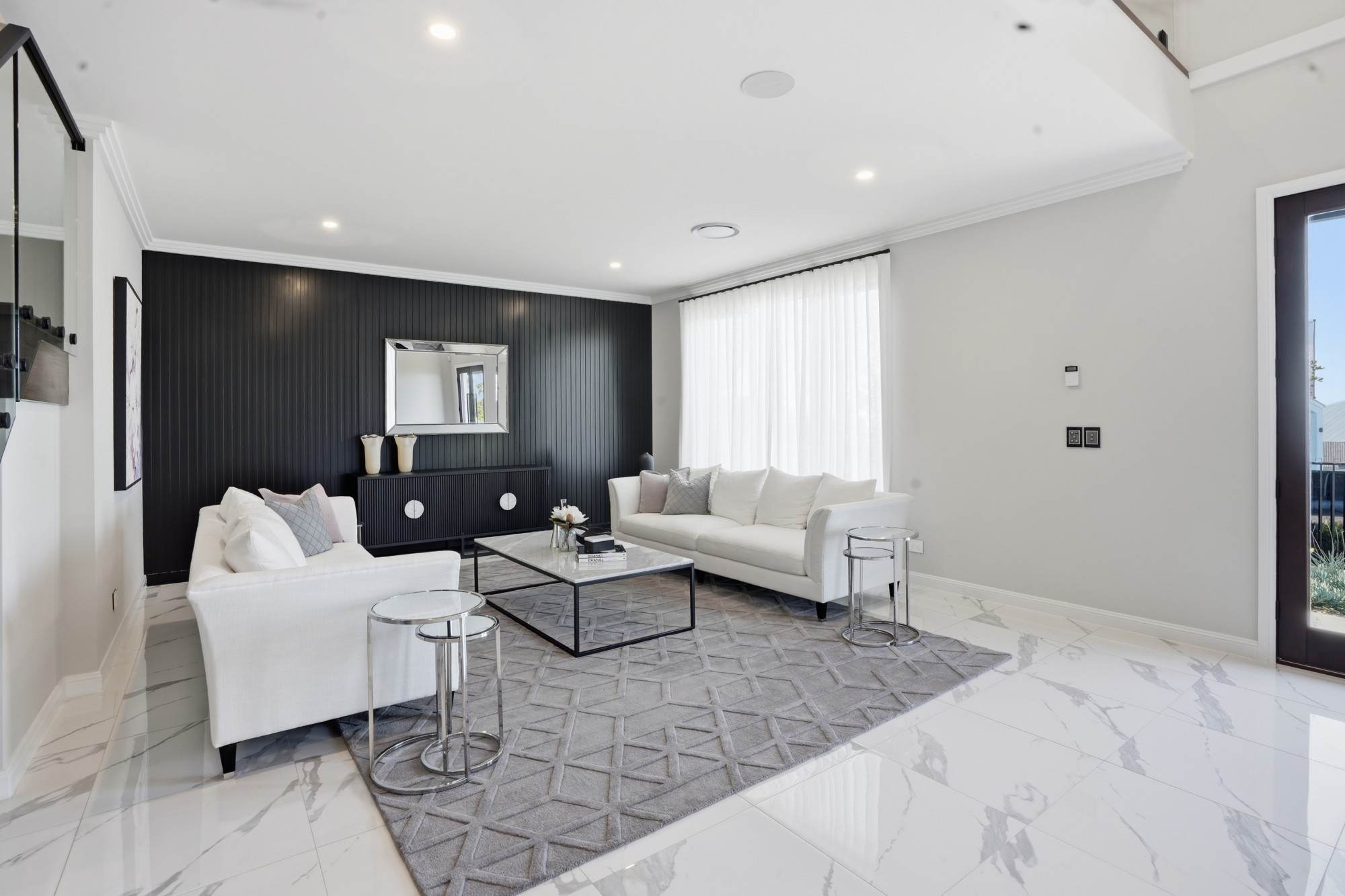 Formal lounge from the entry, with sheer curtains and black panelled wall