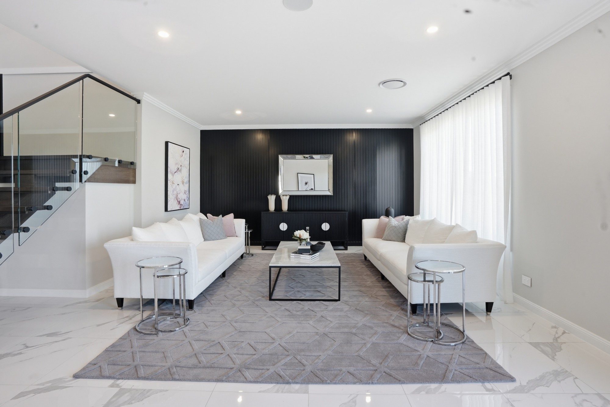 Formal lounge with twin white sofas against a black panelled feature wall