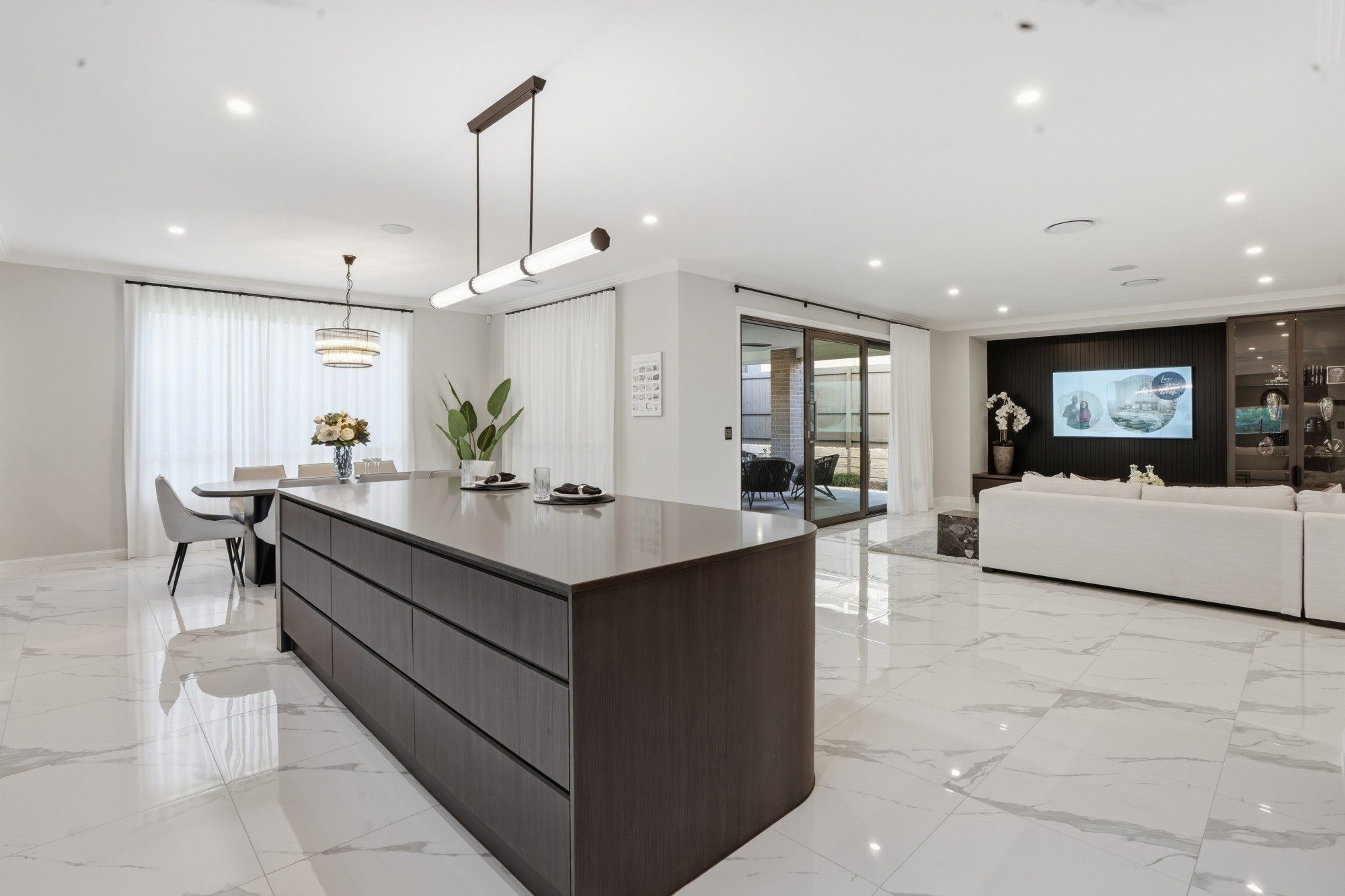 New-build kitchen with a curved timber island and marble-look floors