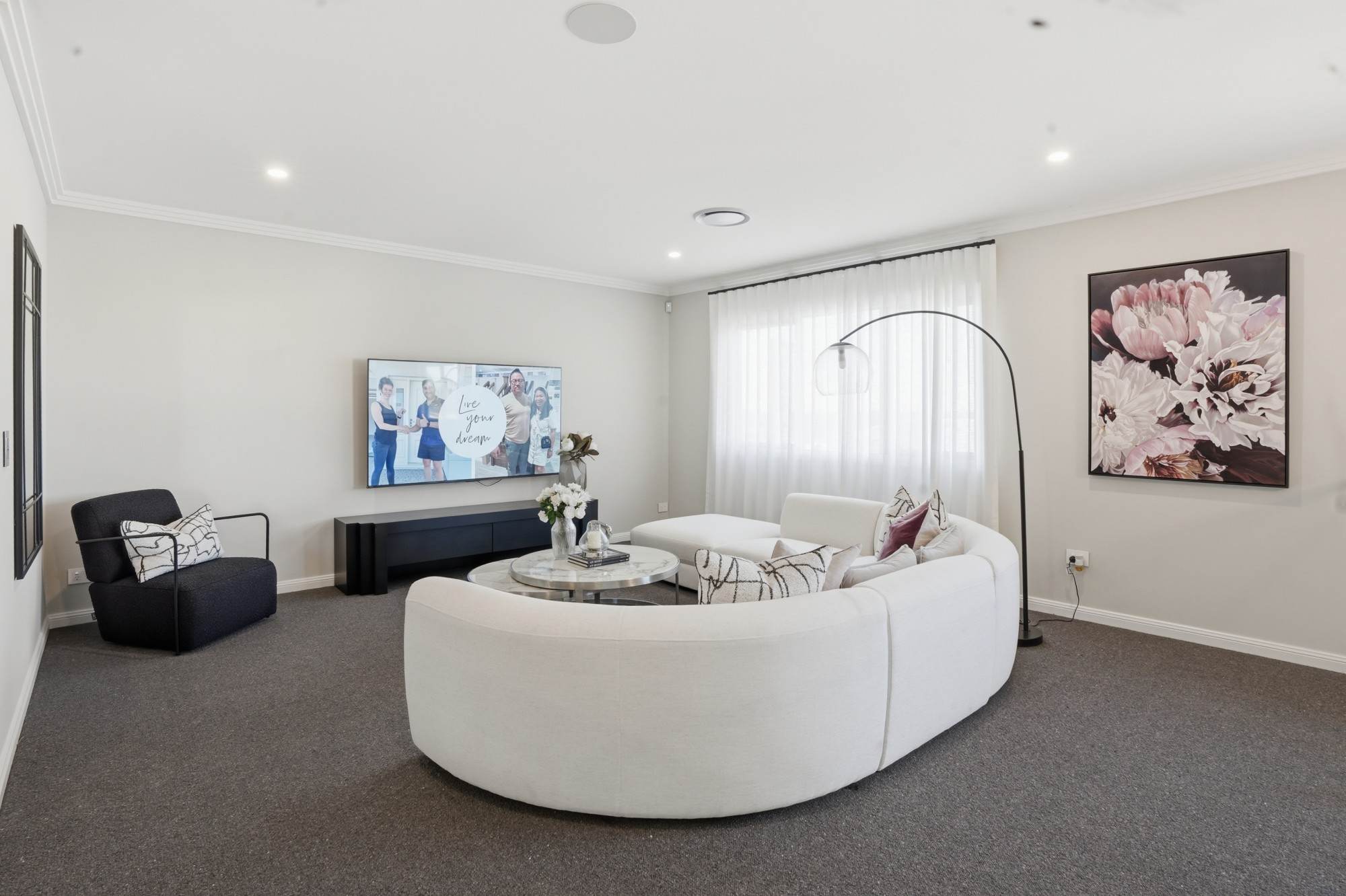 Media room with curved modular sofa and large floral artwork